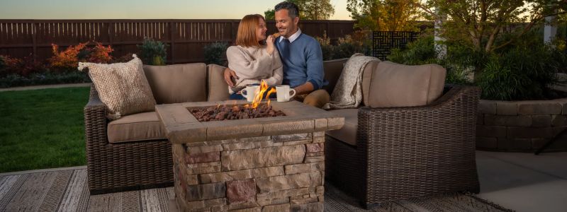 Man and woman sitting on outdoor sofa by firepit from Villa Outdoors